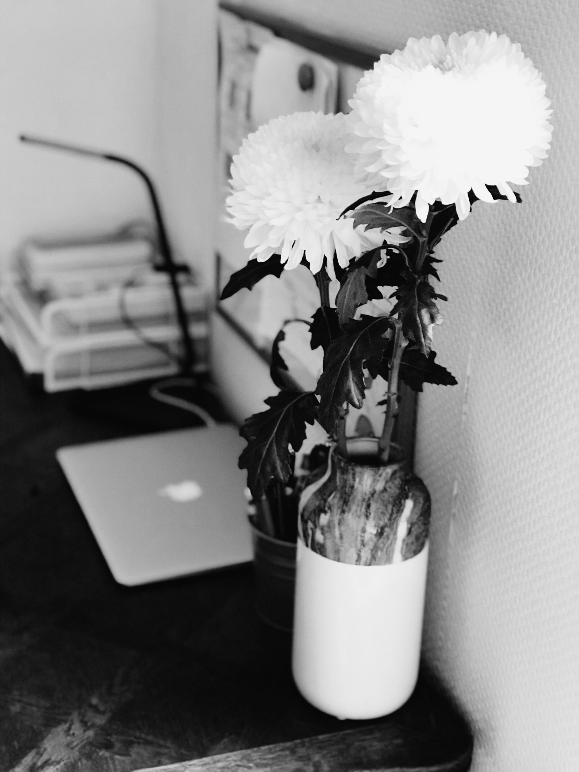 A table with some flowers and a MacBook.